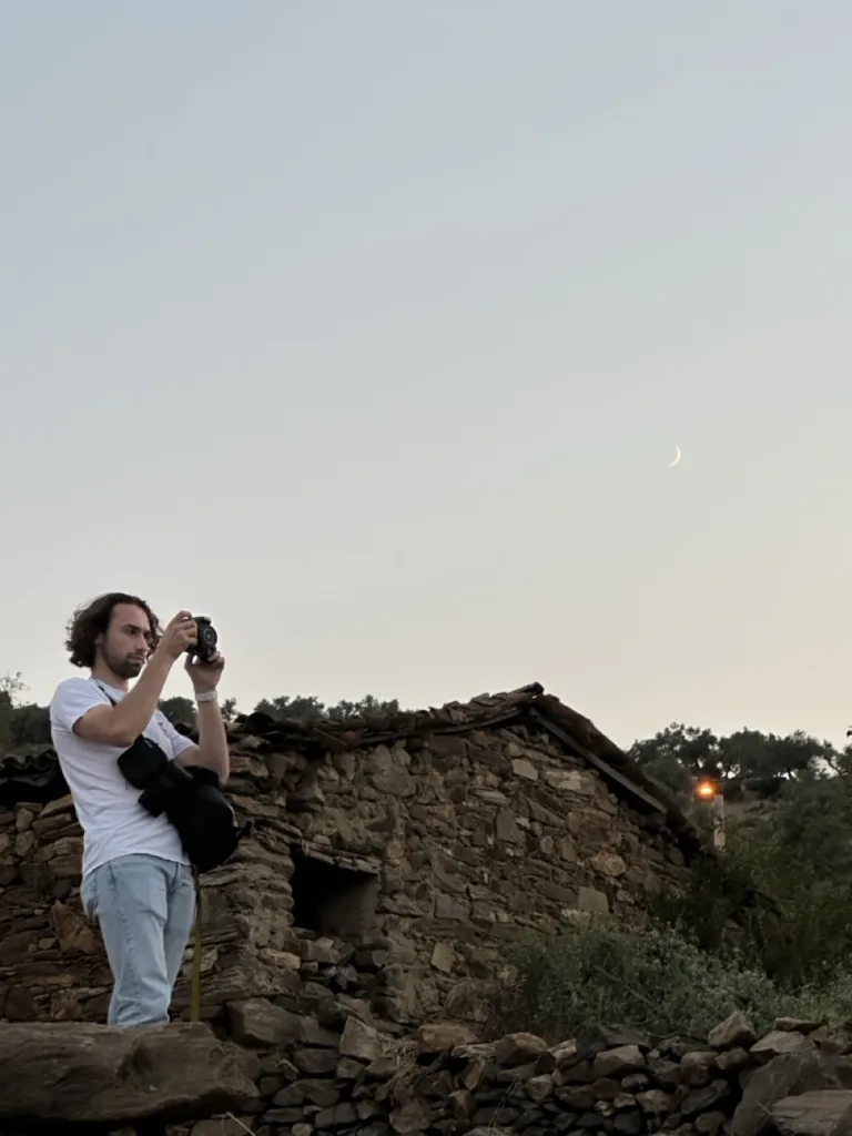 Vidéaste de Muss Production en tournage en extérieur, caméra à l’épaule