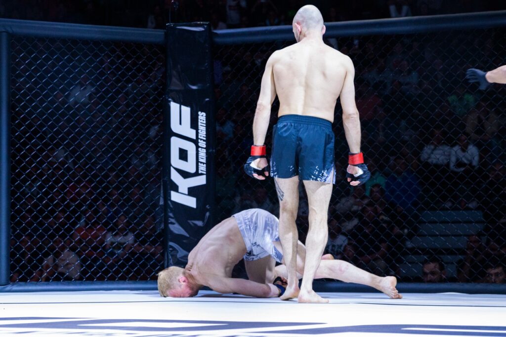 Combattant au sol sur le ring du King of Fighter