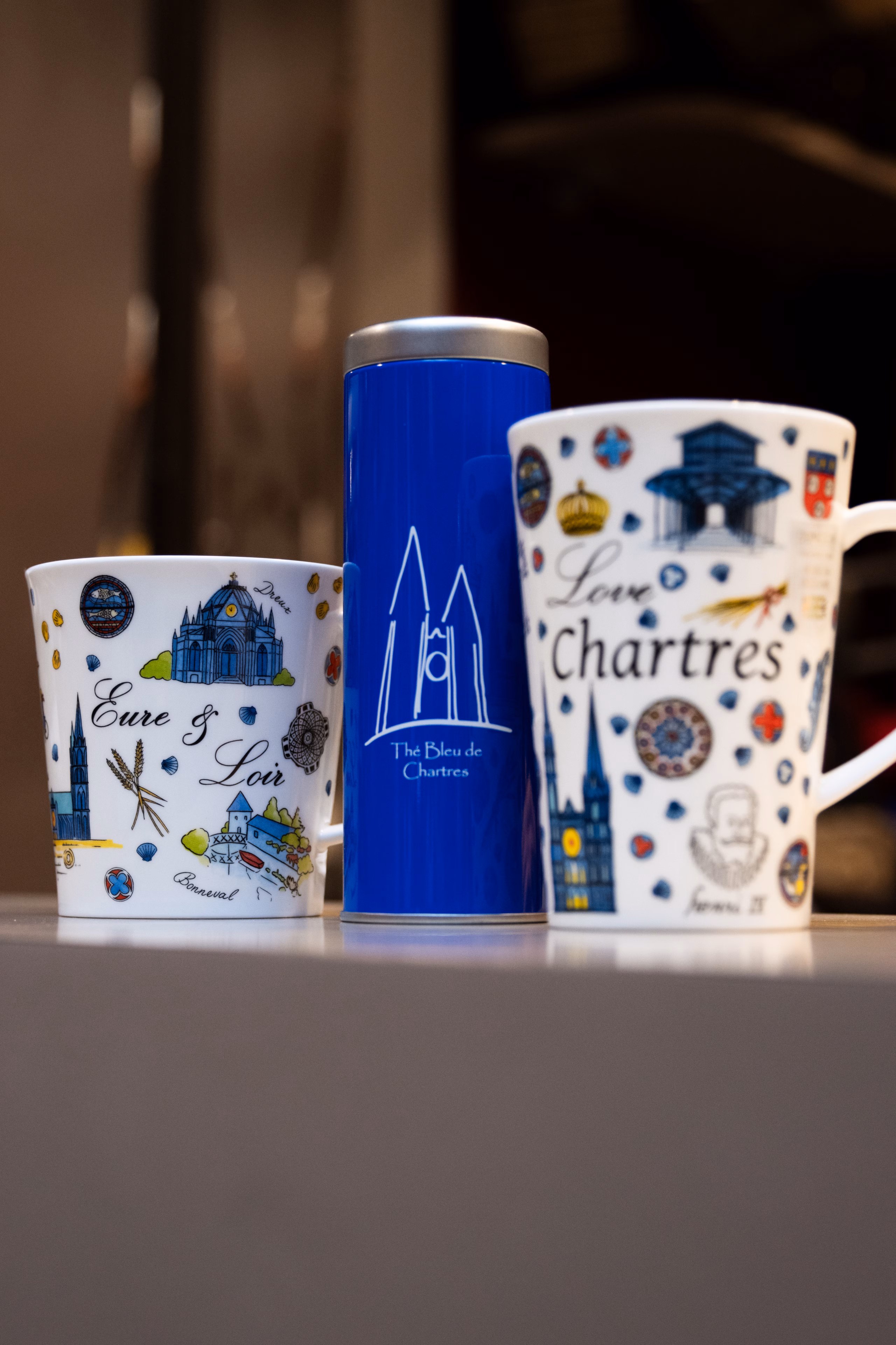Mugs décorés Eure-et-Loir et Chartres encadrant une boîte de thé bleue