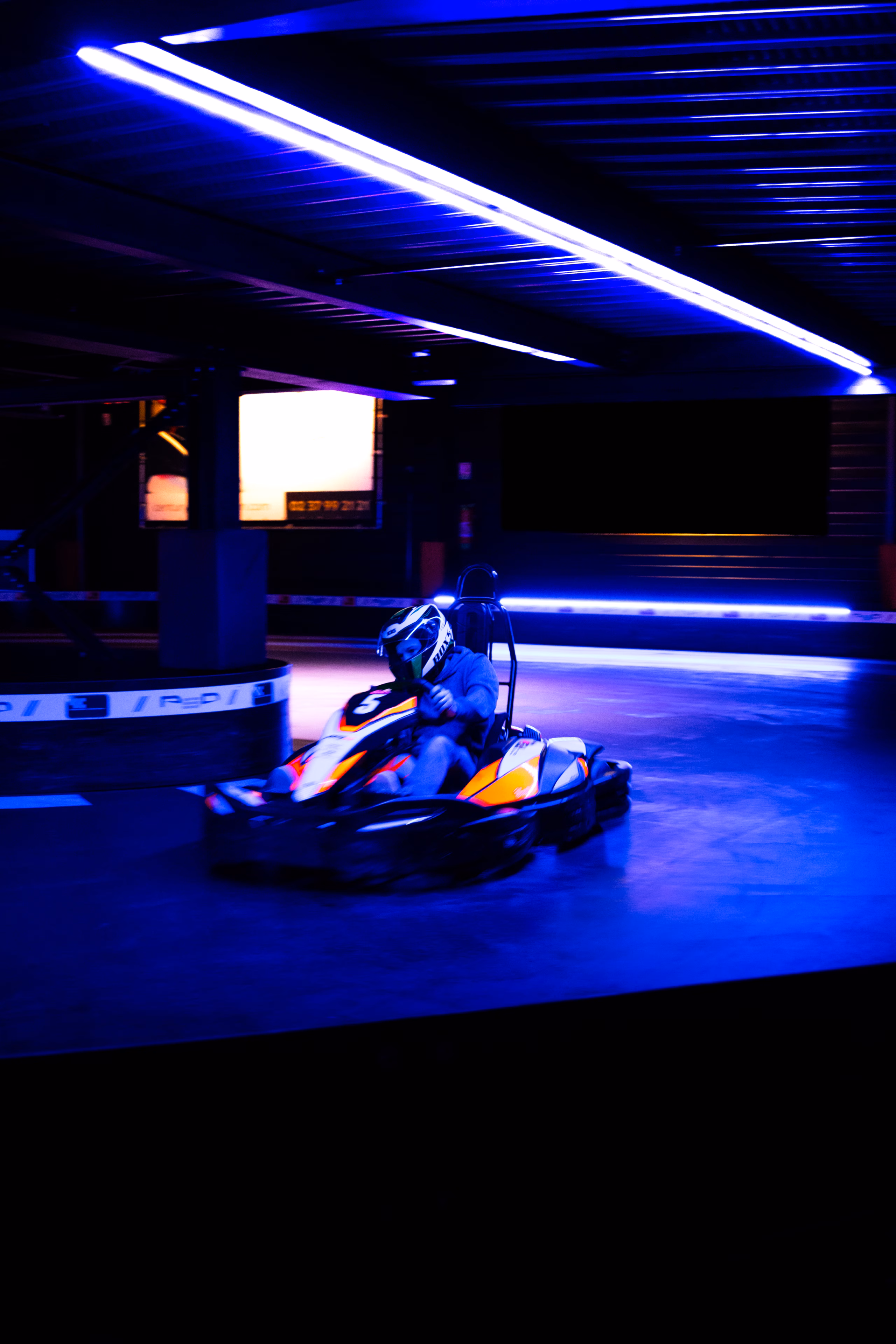 Kart en piste sous les néons bleus d'un circuit couvert
