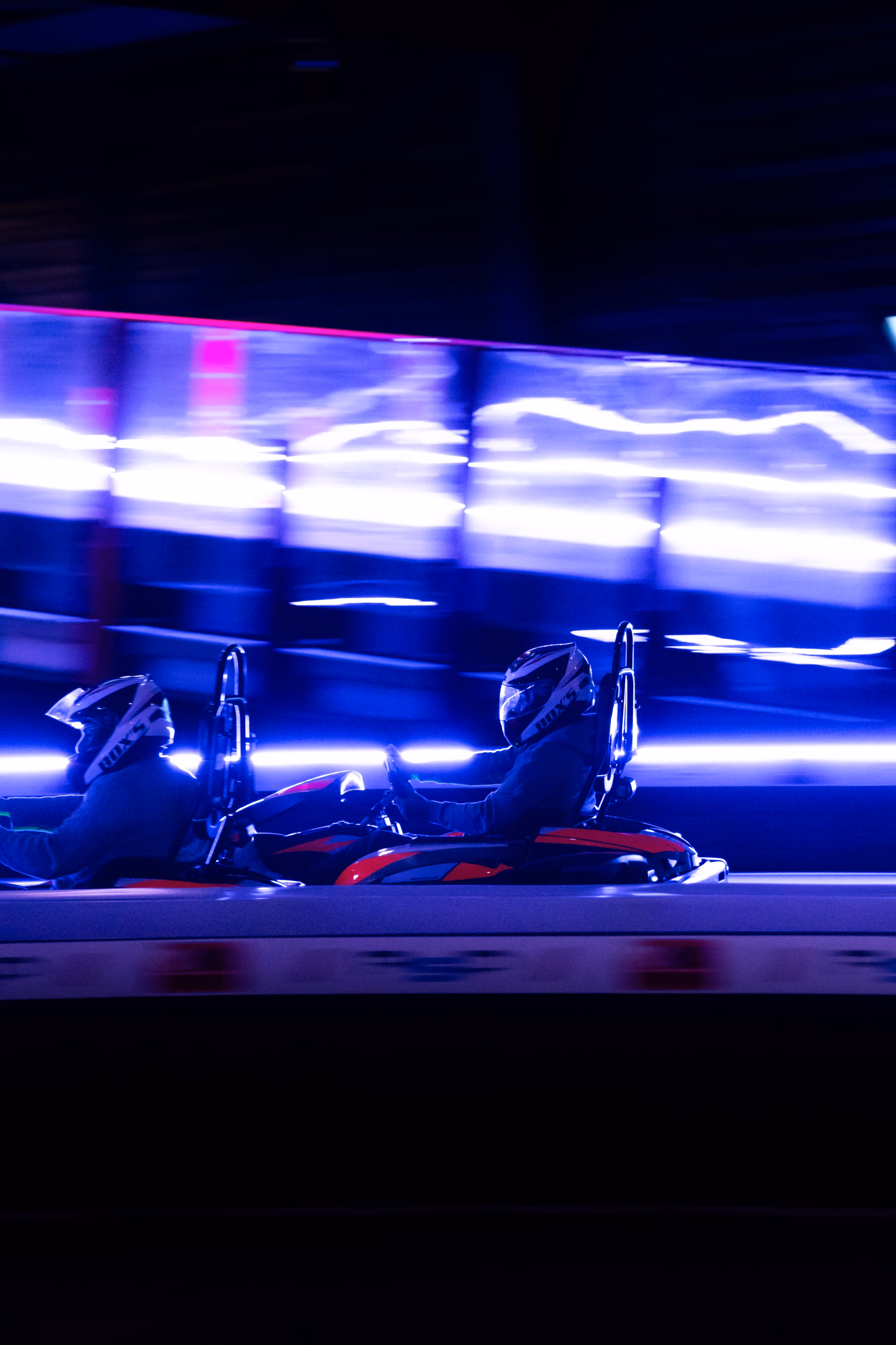 Deux karts côte à côte en piste, filé lumineux bleu en arrière-plan
