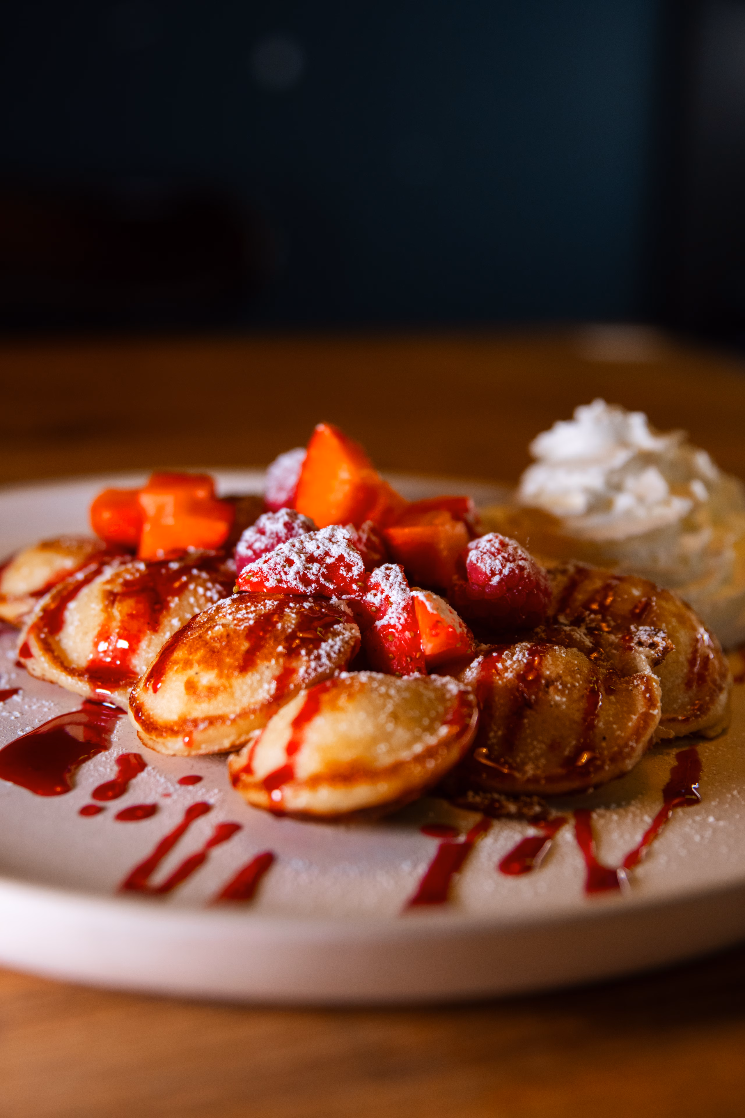 Assiette de mini-pancakes aux fraises et framboises, chantilly et coulis rouge